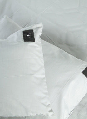 Grounding pillows and sheets showing a black Aarding®  grounding connector