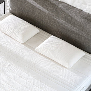 Two Tuur® Pillows on a mattress. The pillows are made of 100% natural latex.